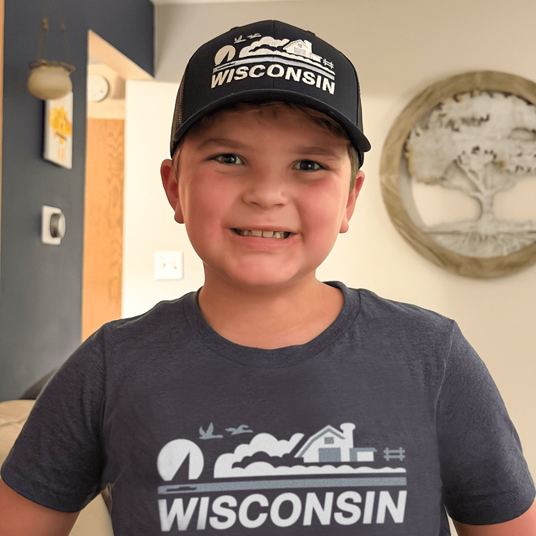Child wearing a 'Wisconsin' cap and t-shirt indoors